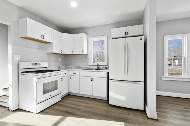 kitchen featuring white cabinets, wood-type flooring, white appliances, and sink