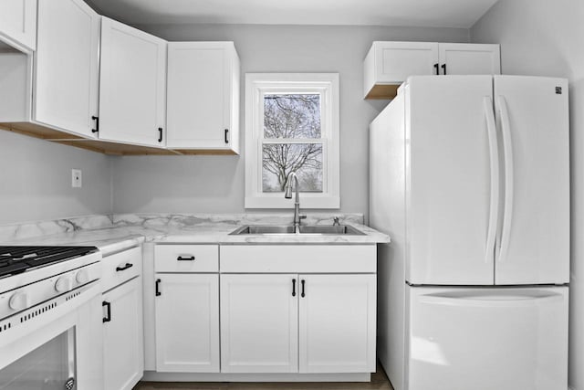 kitchen featuring white appliances, white cabinetry, and sink