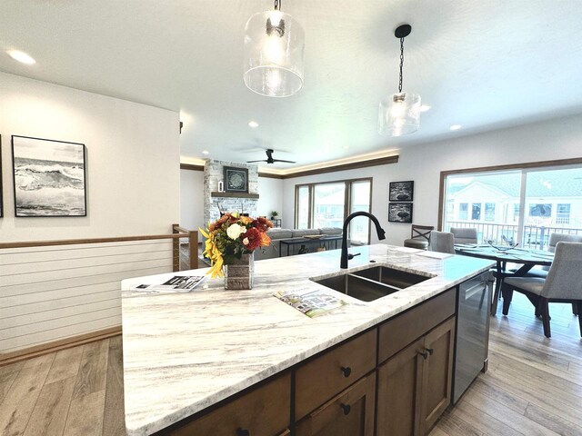 1217 Bay Mist Dr, Green Bay, WI 54311 - kitchen with a sink, dishwasher, dark brown cabinets, light wood-style floors, and light stone countertops