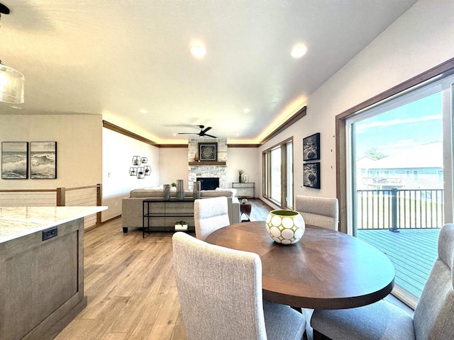 1217 Bay Mist Dr, Green Bay, WI 54311 - dining room with a fireplace, light hardwood / wood-style floors, ceiling fan, and ornamental molding