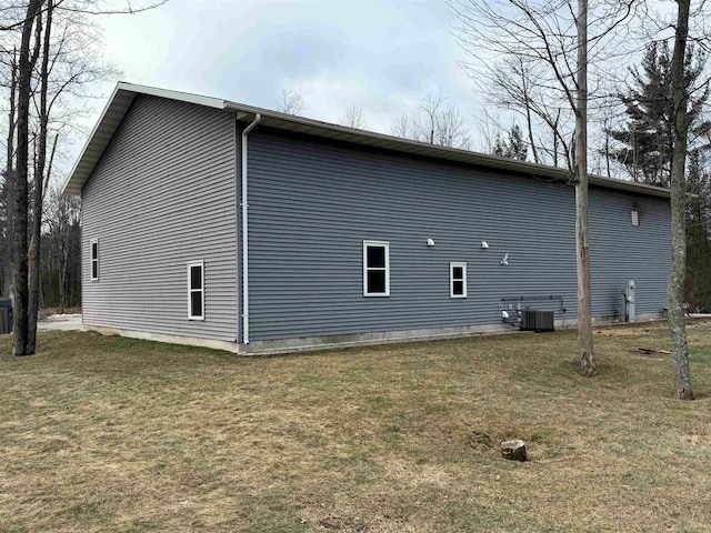 view of property exterior featuring central AC unit and a lawn