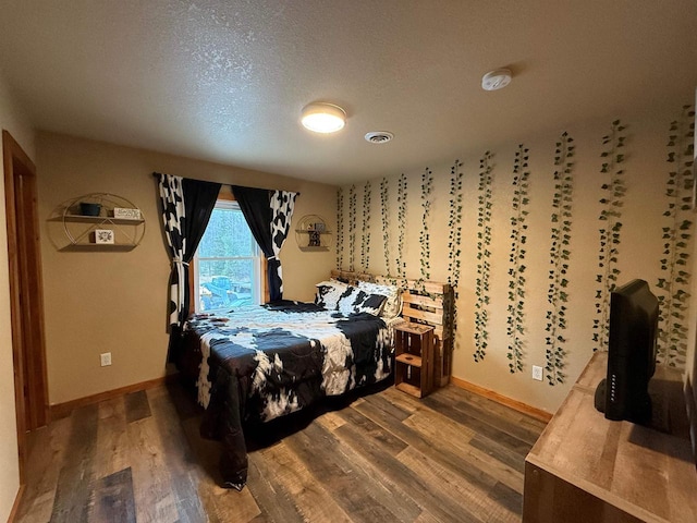 bedroom featuring wood-type flooring and a textured ceiling