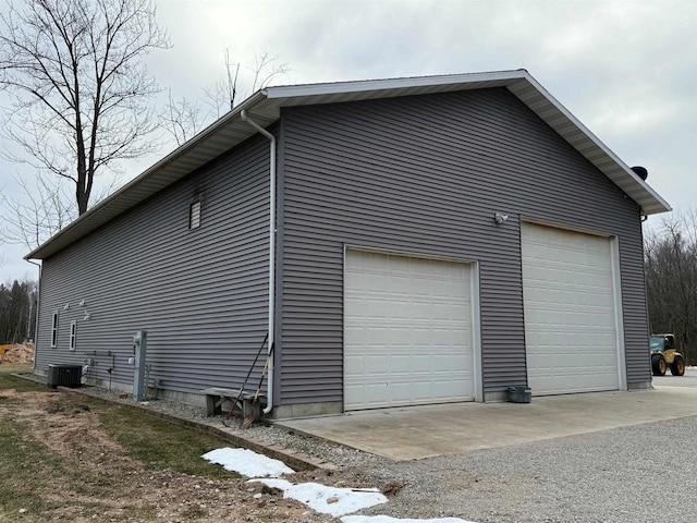 view of side of property featuring a garage, an outdoor structure, and central AC