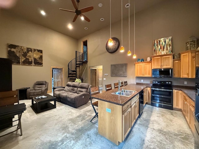 kitchen featuring a kitchen bar, sink, black appliances, pendant lighting, and a high ceiling