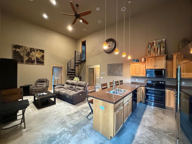 kitchen featuring a kitchen bar, a towering ceiling, ceiling fan, sink, and black appliances