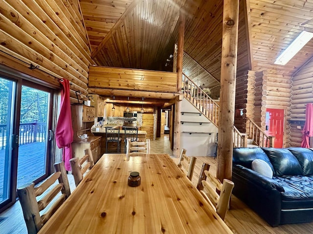 unfurnished dining area with a skylight, rustic walls, wood-type flooring, high vaulted ceiling, and wooden ceiling