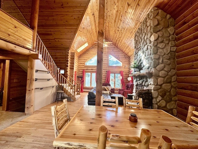 unfurnished dining area with high vaulted ceiling, light hardwood / wood-style floors, wood ceiling, and log walls