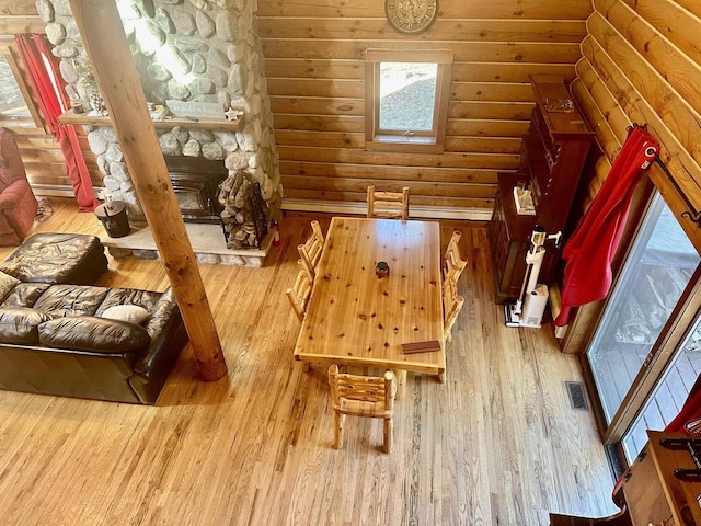 interior space with rustic walls, hardwood / wood-style floors, and a fireplace