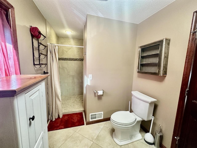 bathroom featuring tile patterned floors, vanity, a textured ceiling, toilet, and curtained shower