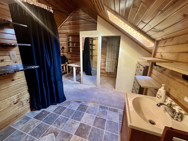 bathroom featuring vanity, lofted ceiling with skylight, wooden walls, built in shelves, and wood ceiling