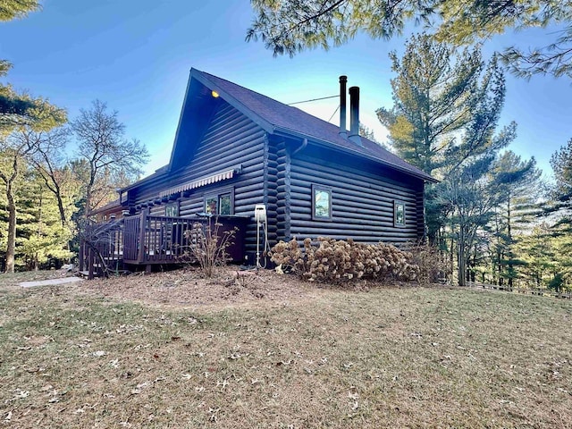 view of side of home featuring a deck and a yard