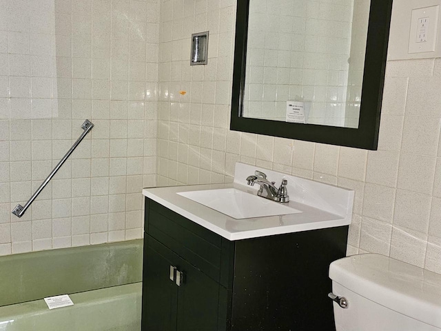 bathroom featuring decorative backsplash, vanity, tile walls, and toilet