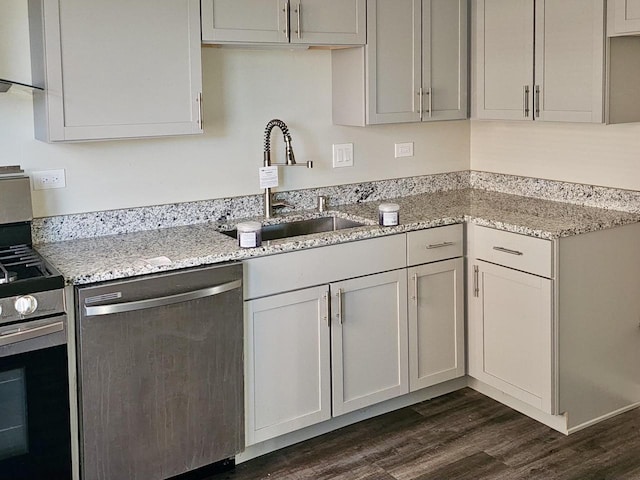 kitchen featuring light stone countertops, appliances with stainless steel finishes, dark hardwood / wood-style floors, and sink