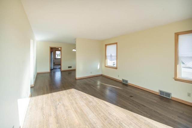 unfurnished room with dark hardwood / wood-style flooring