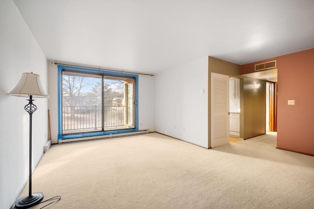 carpeted empty room featuring a baseboard radiator