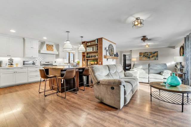 living room featuring light hardwood / wood-style floors and ceiling fan