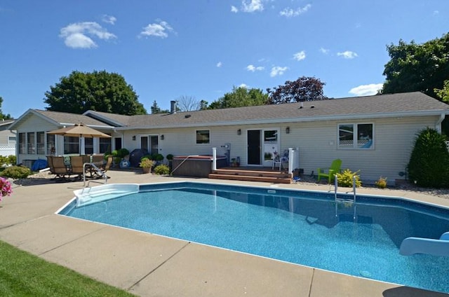 view of swimming pool featuring a hot tub and a patio