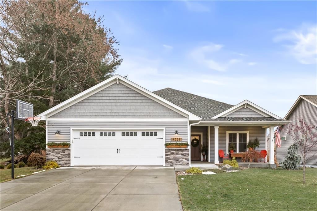 view of front facade with a porch, a garage, and a front lawn