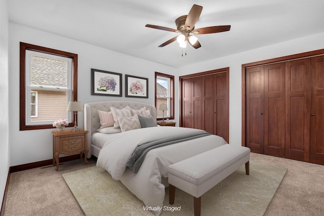 carpeted bedroom with multiple closets and ceiling fan