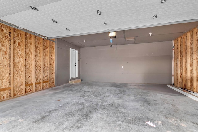 garage with wooden walls and a garage door opener