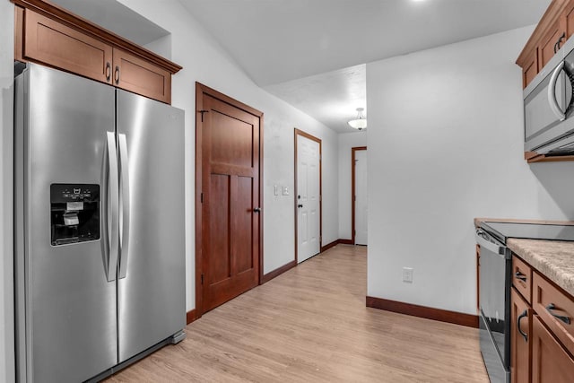 kitchen with stainless steel appliances and light hardwood / wood-style flooring