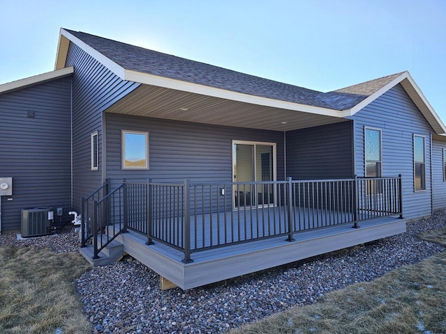 back of property with covered porch and central AC