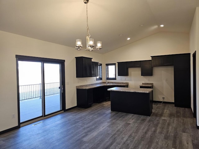 kitchen featuring a center island, sink, dark hardwood / wood-style floors, a notable chandelier, and pendant lighting