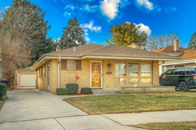 view of front of property featuring a garage, an outbuilding, and a front lawn