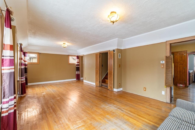 unfurnished living room featuring wood-type flooring and a textured ceiling