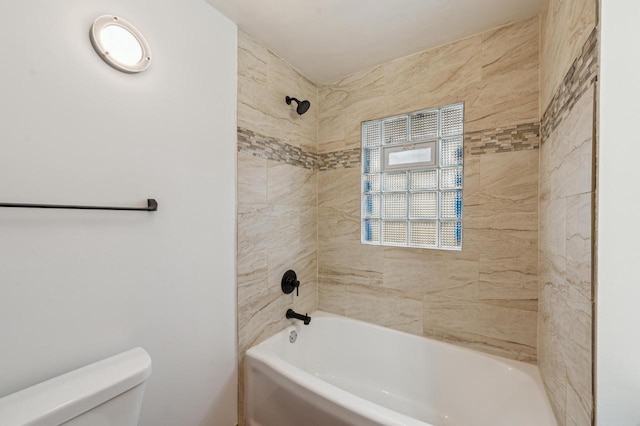 bathroom with tiled shower / bath combo and toilet