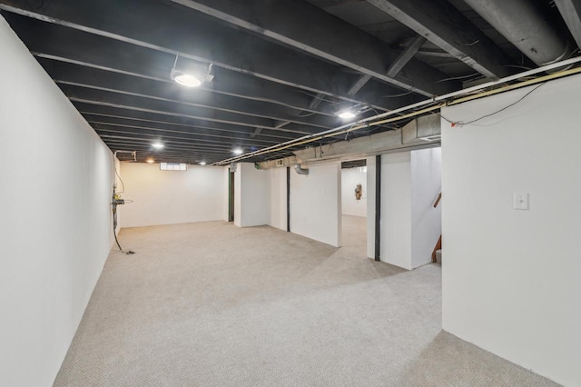 basement featuring light carpet