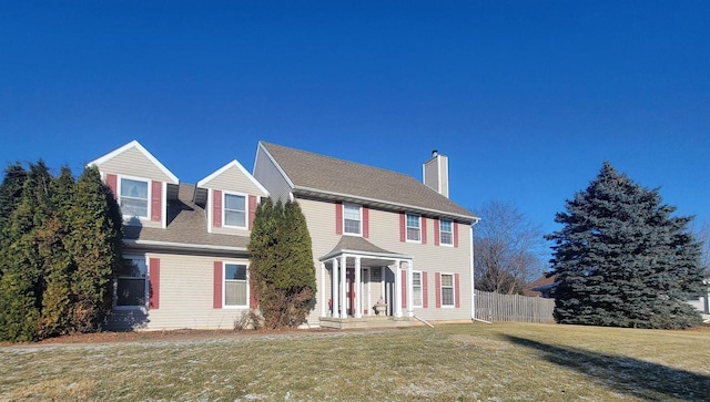 colonial inspired home featuring a front lawn