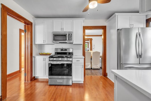 kitchen featuring white cabinetry, ceiling fan, light wood-type flooring, and appliances with stainless steel finishes