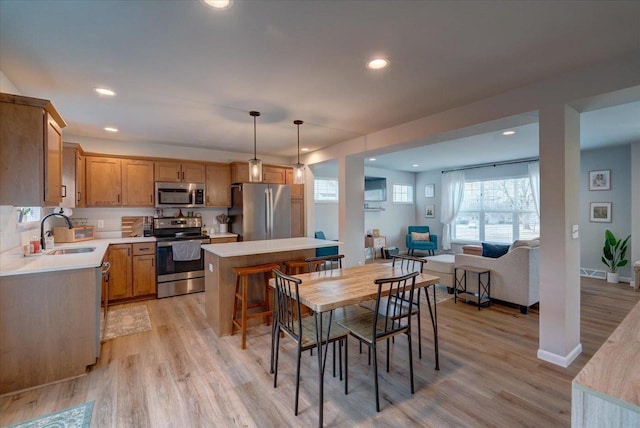 dining area with light wood-type flooring and sink