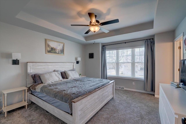 bedroom with ceiling fan, a raised ceiling, and carpet floors