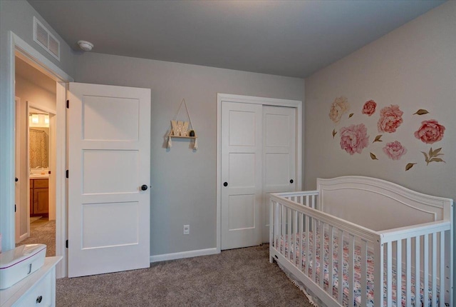 carpeted bedroom featuring a closet and a nursery area