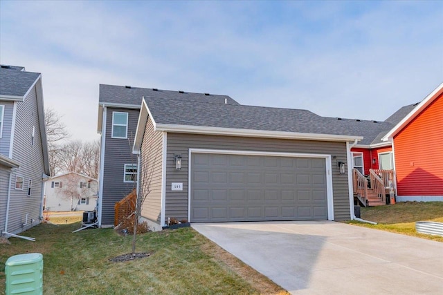 view of front of house with central air condition unit, a front lawn, and a garage