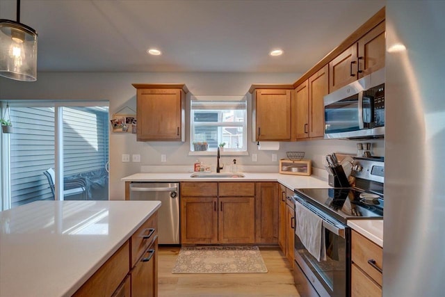 kitchen with a healthy amount of sunlight, sink, pendant lighting, and appliances with stainless steel finishes