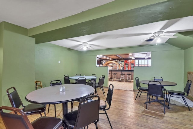 dining area with ceiling fan, light hardwood / wood-style floors, and indoor bar