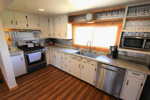 kitchen with sink, dark wood-type flooring, stainless steel appliances, backsplash, and white cabinets