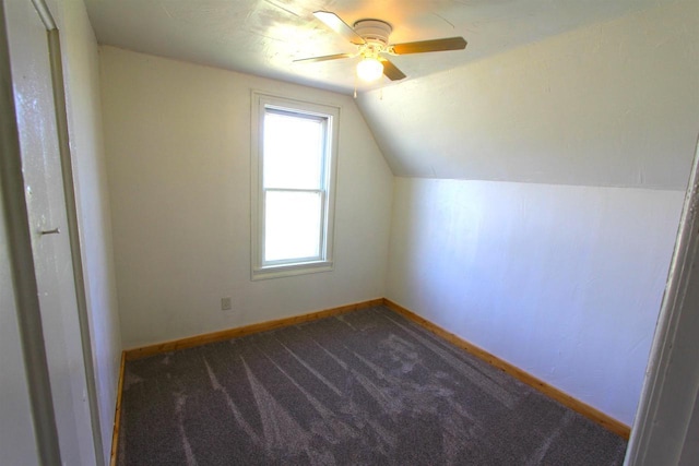 additional living space with ceiling fan, dark carpet, and vaulted ceiling