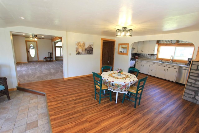 dining room featuring dark hardwood / wood-style floors, ceiling fan, sink, and vaulted ceiling