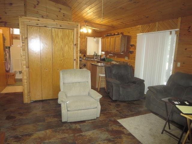 living room with ceiling fan, wooden ceiling, and wood walls