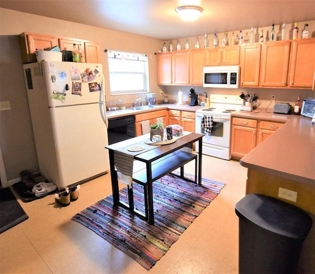 kitchen with light brown cabinets, white appliances, and sink