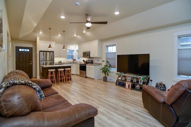 living room featuring ceiling fan and light hardwood / wood-style floors