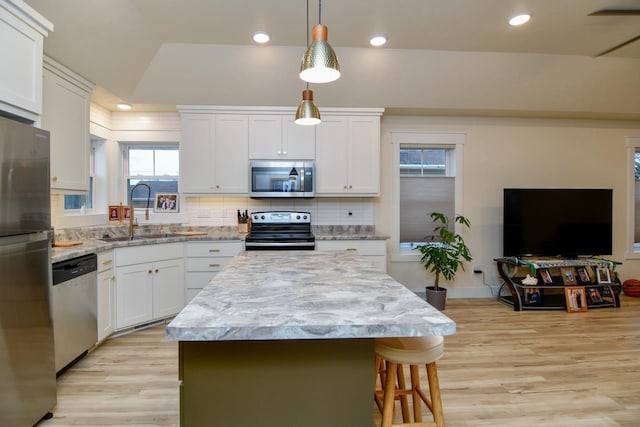 kitchen with white cabinets, a kitchen island, sink, and stainless steel appliances