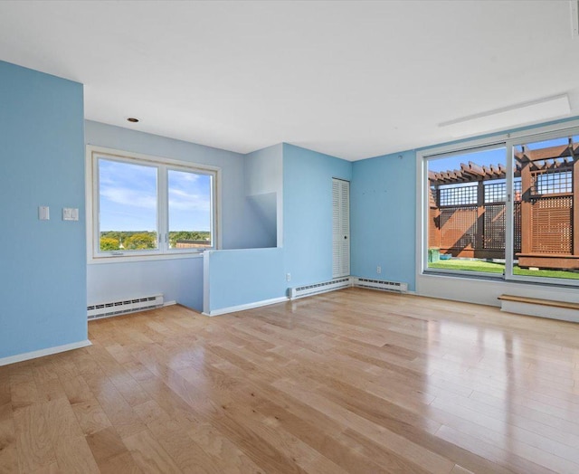 spare room with light wood-type flooring and a baseboard radiator