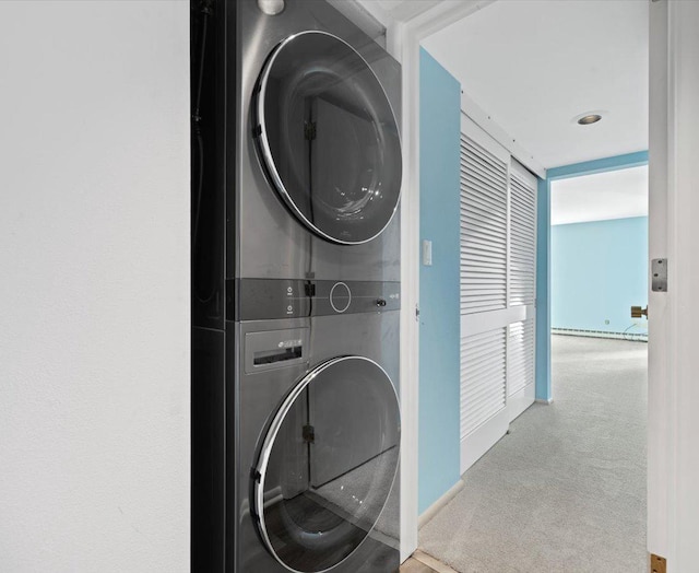 clothes washing area with carpet and stacked washer and dryer