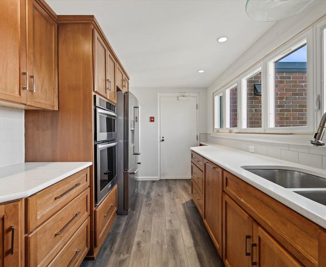 kitchen with tasteful backsplash, sink, dark hardwood / wood-style flooring, and appliances with stainless steel finishes