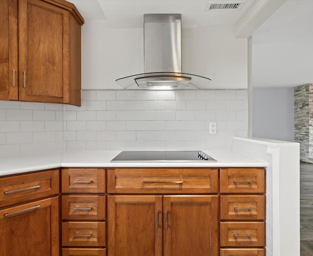 kitchen featuring island exhaust hood, tasteful backsplash, and black electric cooktop